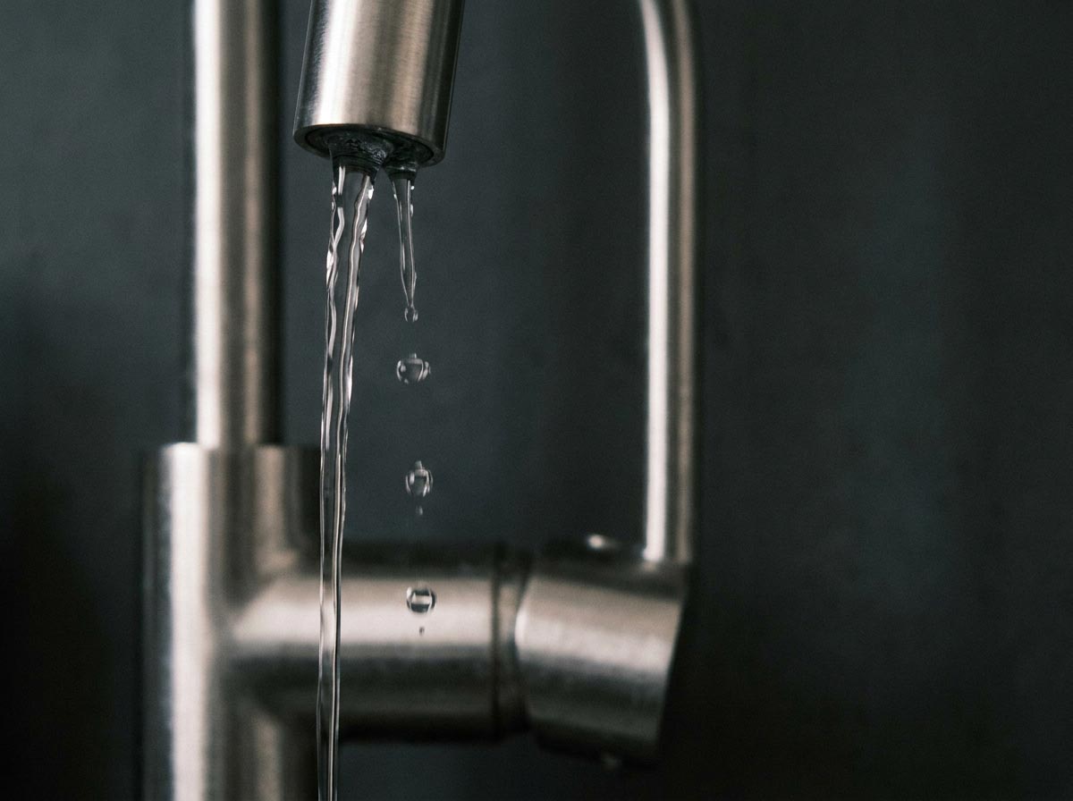 Eau s'écoulant d'un robinet de cuisine dans un verre