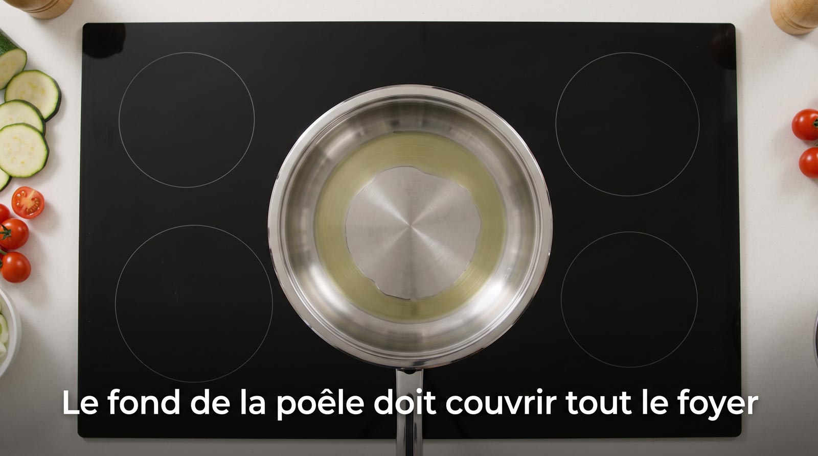 Poêle inox posée sur un foyer à induction dont le fond couvre toute la zone de chauffe